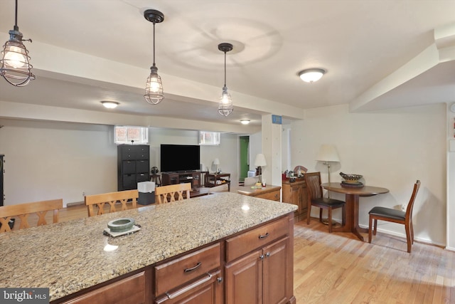 3615 22nd St N, Arlington, VA 22207 - kitchen featuring light stone countertops, hanging light fixtures, light wood-style floors, and brown cabinetry