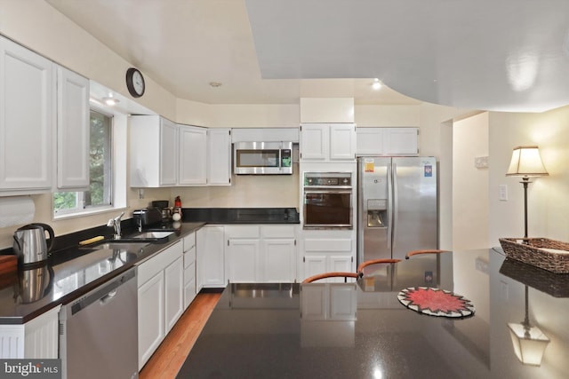 3615 22nd St N, Arlington, VA 22207 - kitchen with stainless steel appliances, a sink, dark countertops, and white cabinets