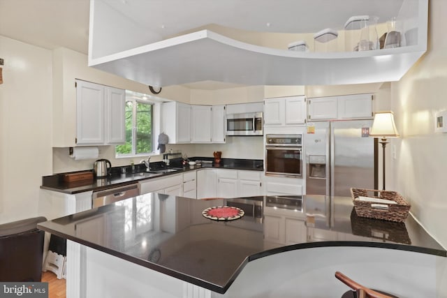 3615 22nd St N, Arlington, VA 22207 - kitchen featuring stainless steel appliances, dark countertops, a sink, and white cabinetry