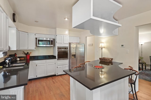 3615 22nd St N, Arlington, VA 22207 - kitchen featuring stainless steel appliances, dark countertops, light wood-style flooring, and a sink