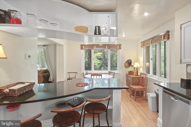 3615 22nd St N, Arlington, VA 22207 - kitchen featuring dishwasher, light wood-type flooring, a breakfast bar, dark countertops, and plenty of natural light