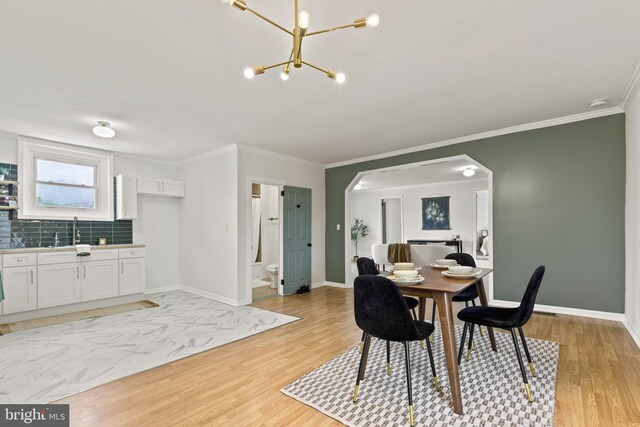 106 1st Ave, Lincoln University, PA 19352 - dining space featuring light wood-style flooring, arched walkways, a chandelier, crown molding, and baseboards