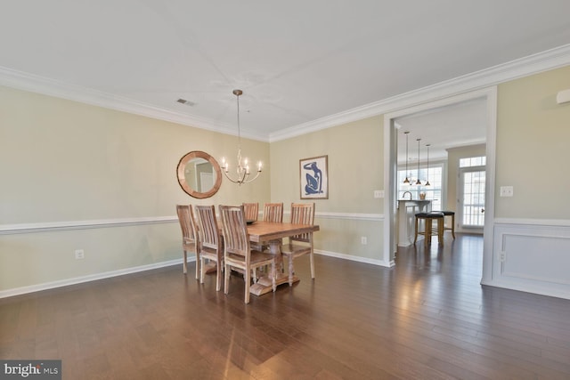 23492 Bluemont Chapel Ter, Ashburn, VA 20148 - dining area featuring a chandelier, ornamental molding, dark wood-style flooring, and wainscoting