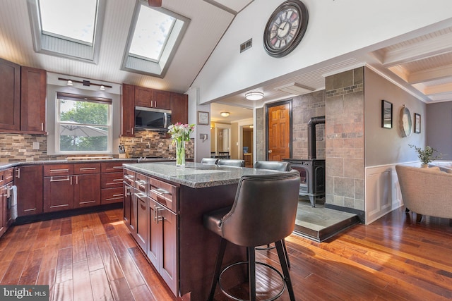 1104 N Pleasantview Rd, Pottstown, PA 19464 - kitchen with a wood stove, dark wood-style flooring, a skylight, stainless steel microwave, and a kitchen island