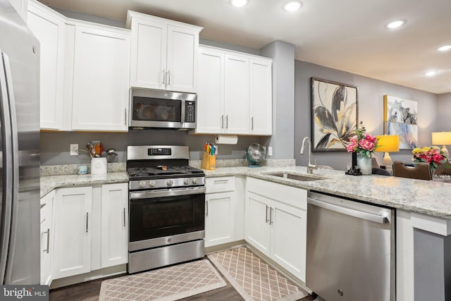117 King St Unit A, Bensalem, PA 19020 - kitchen with appliances with stainless steel finishes, a sink, recessed lighting, white cabinets, and light stone countertops