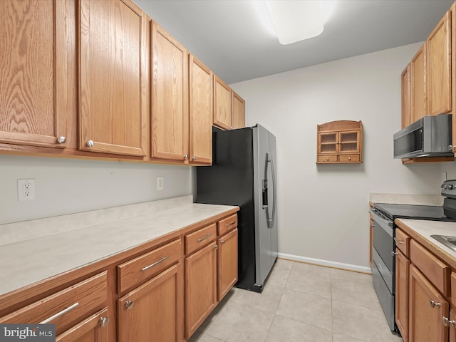 2608 Chapel Lake Dr Unit 112, Gambrills, MD 21054 - kitchen with stainless steel appliances, light countertops, light tile patterned floors, and baseboards