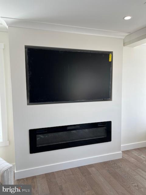 11 Selma Dr, Manahawkin, NJ 08050 - detailed view of a glass covered fireplace, wood finished floors, recessed lighting, ornamental molding, and baseboards