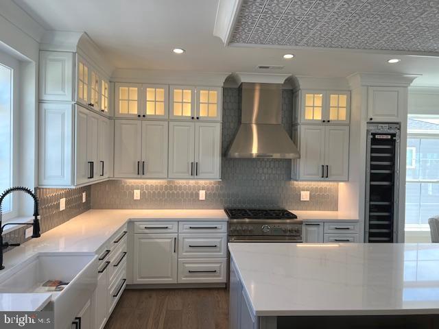 11 Selma Dr, Manahawkin, NJ 08050 - kitchen with wall chimney exhaust hood, beverage cooler, a sink, white cabinets, and recessed lighting