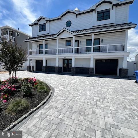 11 Selma Dr, Manahawkin, NJ 08050 - view of front facade with a standing seam roof, decorative driveway, a garage, metal roof, and a balcony