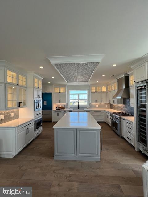 11 Selma Dr, Manahawkin, NJ 08050 - kitchen with wall chimney exhaust hood, stainless steel appliances, beverage cooler, a center island, and white cabinets