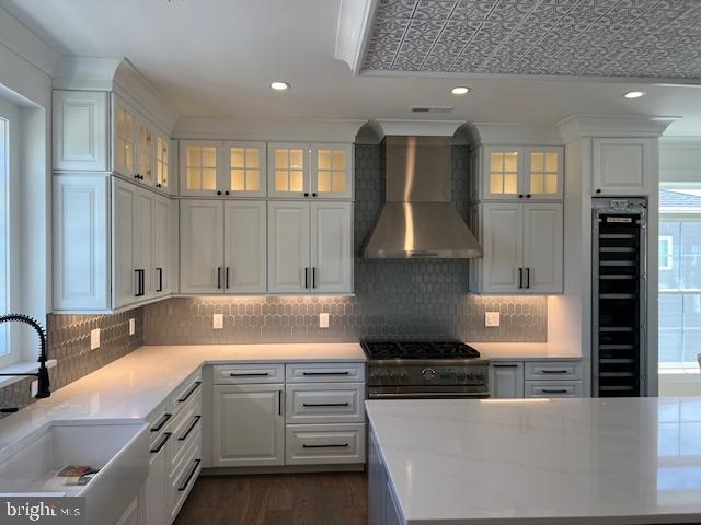 11 Selma Dr, Manahawkin, NJ 08050 - kitchen with wall chimney exhaust hood, a sink, stainless steel range, wine cooler, and white cabinetry