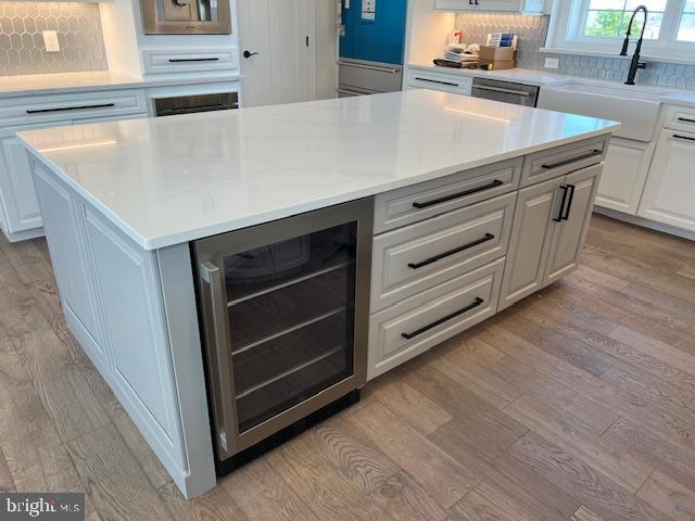 11 Selma Dr, Manahawkin, NJ 08050 - kitchen featuring beverage cooler, a sink, light wood-style floors, and light countertops