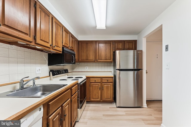 801 N Howard St Unit 305, Alexandria, VA 22304 - kitchen with freestanding refrigerator, white electric range, black microwave, a sink, and decorative backsplash