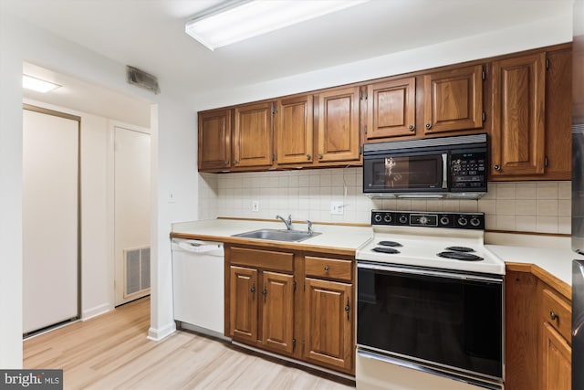 801 N Howard St Unit 305, Alexandria, VA 22304 - kitchen featuring white appliances, a sink, light countertops, and backsplash