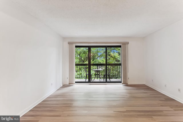 801 N Howard St Unit 305, Alexandria, VA 22304 - unfurnished room with light wood-style floors, baseboards, and a textured ceiling