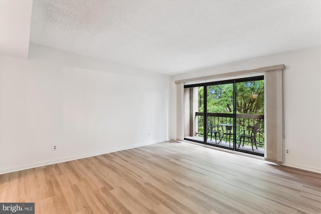 801 N Howard St Unit 305, Alexandria, VA 22304 - spare room featuring wood finished floors, baseboards, and a textured ceiling