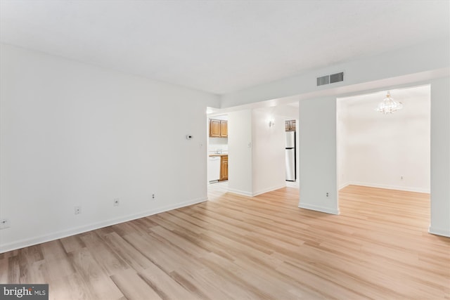 801 N Howard St Unit 305, Alexandria, VA 22304 - spare room featuring light wood finished floors, a chandelier, and baseboards