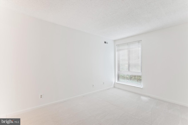 801 N Howard St Unit 305, Alexandria, VA 22304 - spare room featuring baseboards, light colored carpet, and a textured ceiling