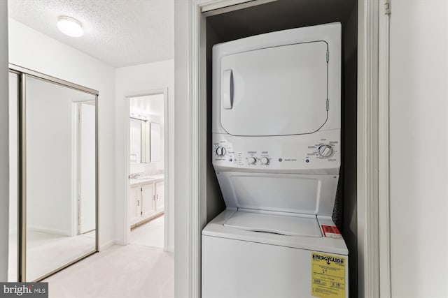801 N Howard St Unit 305, Alexandria, VA 22304 - laundry room with estacked washer and dryer, a textured ceiling, and carpet