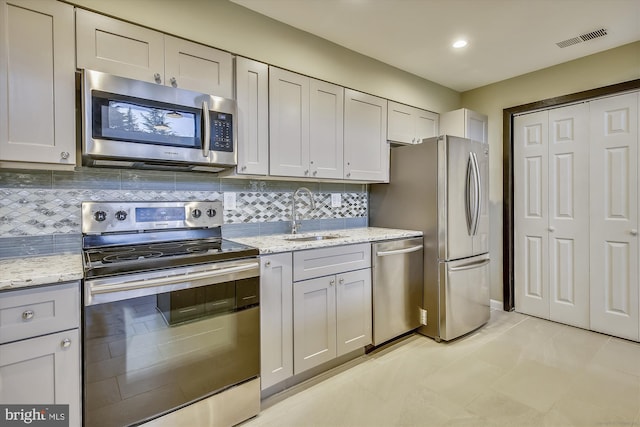 801 N Howard St Unit 305, Alexandria, VA 22304 - kitchen with appliances with stainless steel finishes, a sink, decorative backsplash, light stone countertops, and recessed lighting