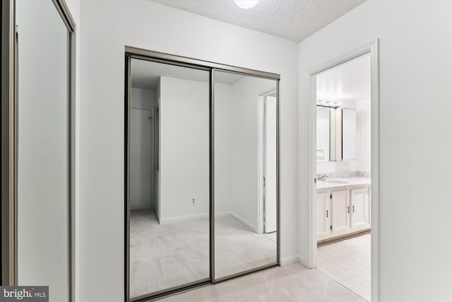 801 N Howard St Unit 305, Alexandria, VA 22304 - unfurnished bedroom with a textured ceiling, a closet, light carpet, ensuite bathroom, and a sink