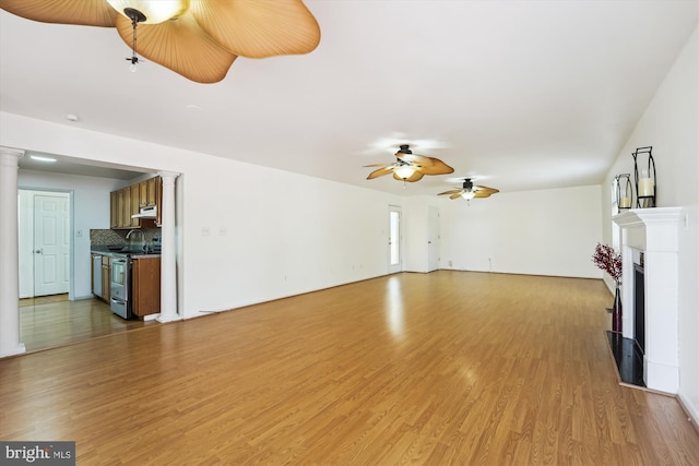 6775 Amherst Rd, Bryans Road, MD 20616 - unfurnished living room with light wood finished floors, a fireplace, a ceiling fan, and decorative columns