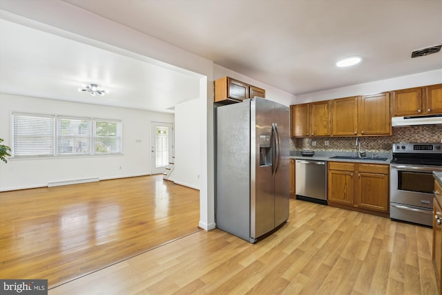 6775 Amherst Rd, Bryans Road, MD 20616 - kitchen with stainless steel appliances, under cabinet range hood, a baseboard radiator, a sink, and light wood-type flooring