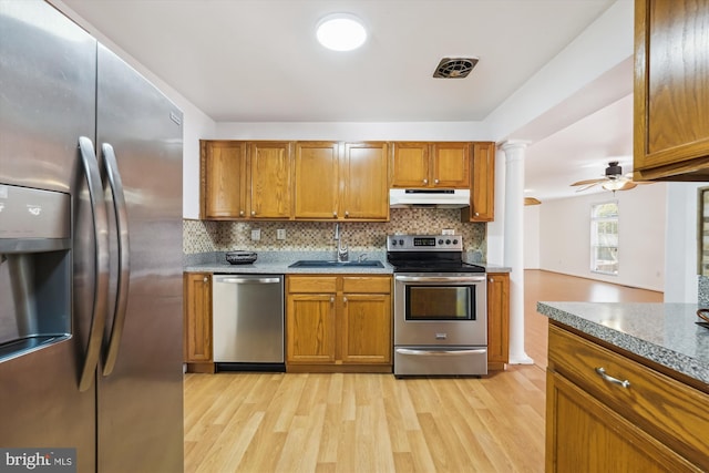 6775 Amherst Rd, Bryans Road, MD 20616 - kitchen featuring appliances with stainless steel finishes, under cabinet range hood, decorative columns, and light wood-type flooring