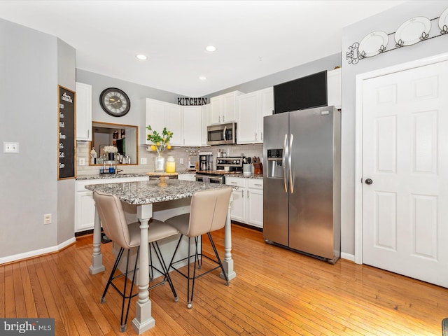 1501 Rambling Way, Frederick, MD 21701 - kitchen with appliances with stainless steel finishes, a breakfast bar area, backsplash, white cabinetry, and recessed lighting