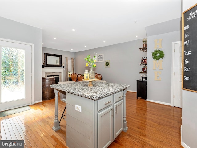 1501 Rambling Way, Frederick, MD 21701 - kitchen featuring light wood finished floors, a breakfast bar, a center island, recessed lighting, and a premium fireplace