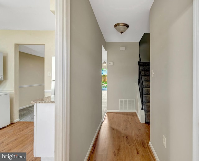 8760 Stoneridge Dr, Manassas, VA 20111 - corridor with stairway, light wood finished floors, baseboards, and washer / clothes dryer