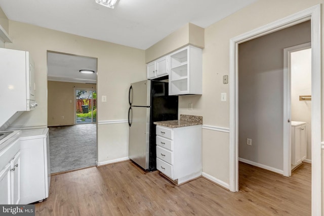 8760 Stoneridge Dr, Manassas, VA 20111 - kitchen with freestanding refrigerator, light wood-style floors, white cabinets, and stacked washer / drying machine