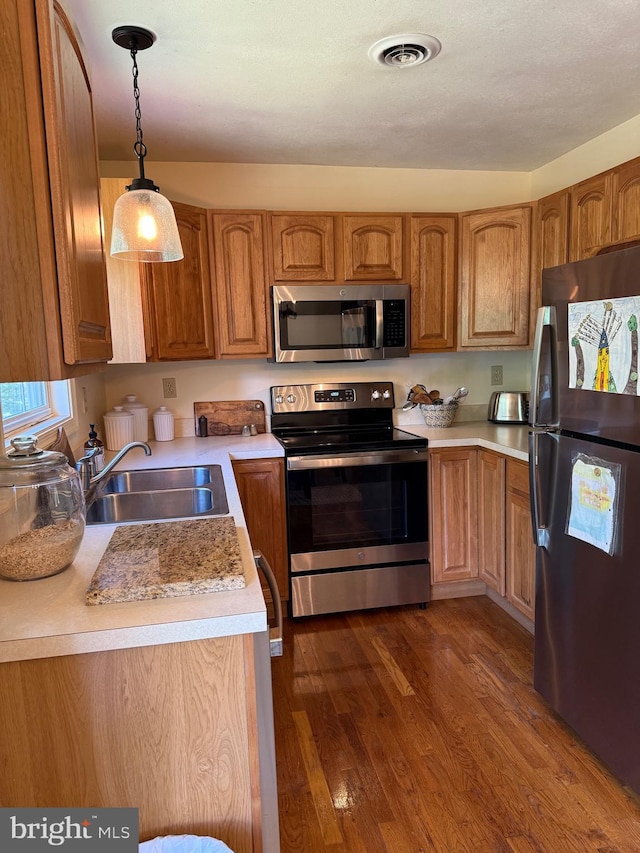 55 Ithica Ln, High View, WV 26808 - kitchen featuring appliances with stainless steel finishes, a sink, pendant lighting, and brown cabinetry
