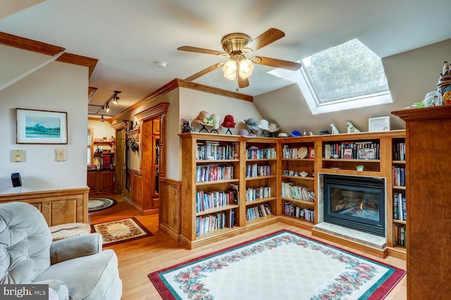 419 Coffee Goss Rd, Marietta, PA 17547 - sitting room featuring a glass covered fireplace, wood finished floors, ceiling fan, a wainscoted wall, and a skylight