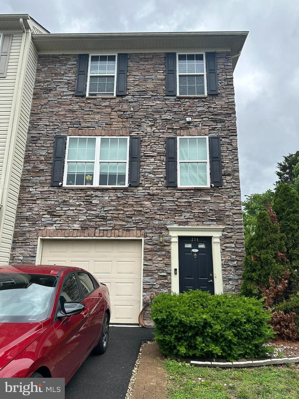 224 Morlatt Ln, Martinsburg, WV 25404 - view of property featuring stone siding, a garage, and asphalt driveway