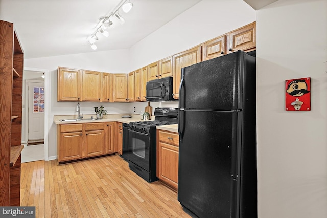 31 S Ann St, Baltimore, MD 21231 - kitchen with black appliances, a sink, light countertops, vaulted ceiling, and light wood-style flooring