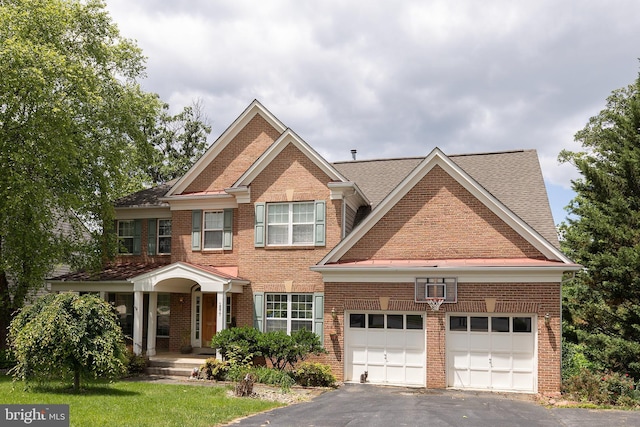 1877 Clayton Ridge Dr, Winchester, VA 22601 - view of front of house with brick siding, asphalt driveway, an attached garage, and roof with shingles