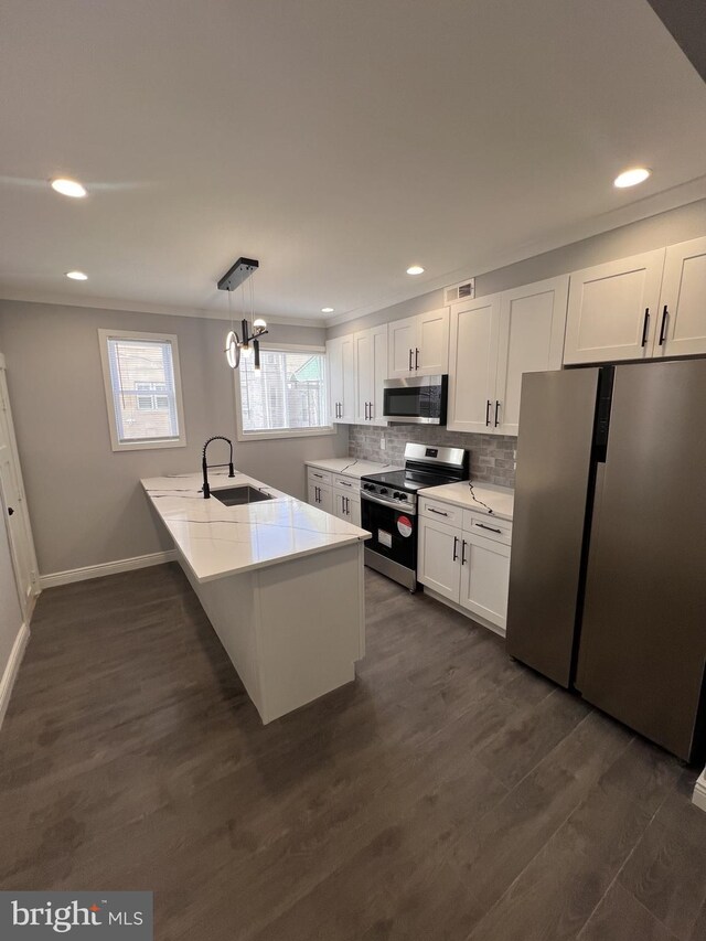1712 W 65th Ave, Philadelphia, PA 19126 - kitchen with appliances with stainless steel finishes, a sink, a peninsula, white cabinetry, and tasteful backsplash