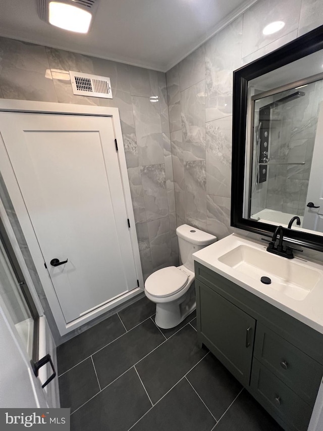 1712 W 65th Ave, Philadelphia, PA 19126 - bathroom featuring tile walls, toilet, vanity, and tile patterned flooring