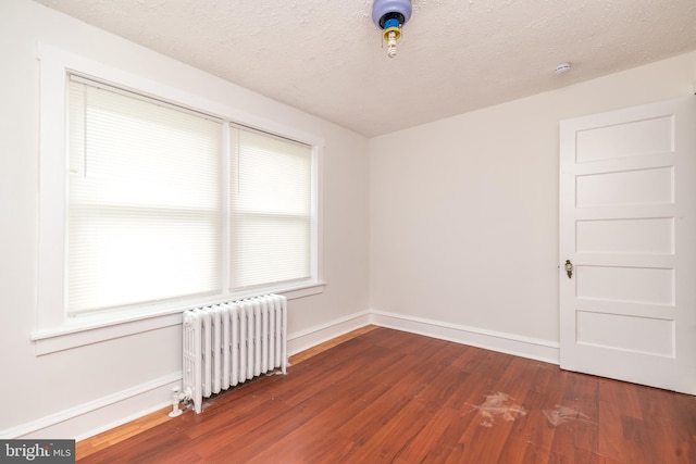 22 E 6th St, Pottstown, PA 19464 - empty room featuring radiator, wood finished floors, baseboards, a textured ceiling, and a smoke detector