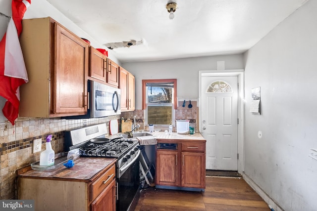 2348 N Mascher St, Philadelphia, PA 19133 - kitchen featuring appliances with stainless steel finishes, dark wood-style flooring, decorative backsplash, and brown cabinetry