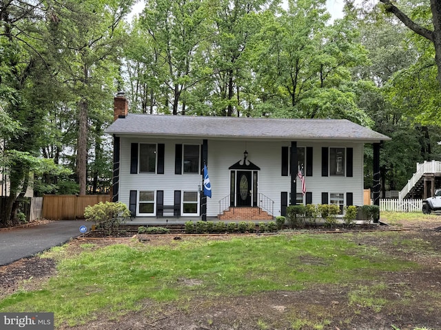 131 Oakwood Dr, Stafford, VA 22554 - split foyer home with a chimney, driveway, and view of wooded area