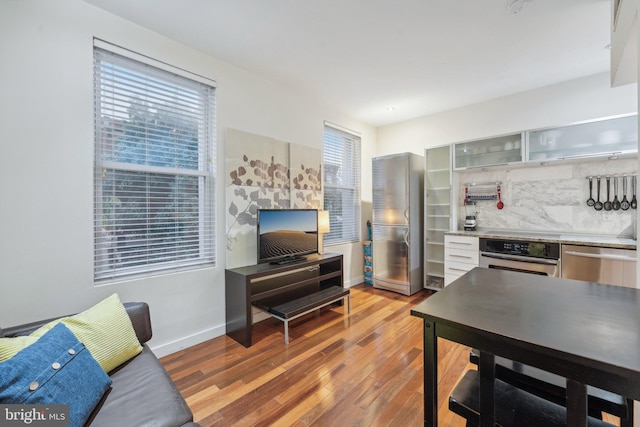 2213 S St Unit 1, Philadelphia, PA 19146 - kitchen featuring appliances with stainless steel finishes, wood finished floors, tasteful backsplash, baseboards, and glass insert cabinets