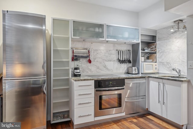 2213 S St Unit 1, Philadelphia, PA 19146 - kitchen with appliances with stainless steel finishes, a sink, light stone countertops, and decorative backsplash