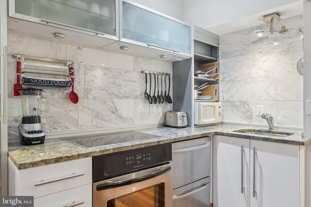 2213 S St Unit 1, Philadelphia, PA 19146 - kitchen featuring appliances with stainless steel finishes, a sink, decorative backsplash, and light stone counters