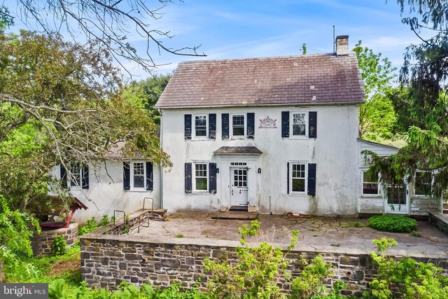 3577 Olde Bedminster Rd, Ottsville, PA 18942 - view of front facade with stucco siding, a patio area, and a chimney
