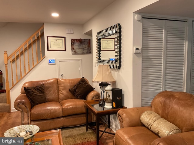 living area with wood finished floors, recessed lighting, and stairs