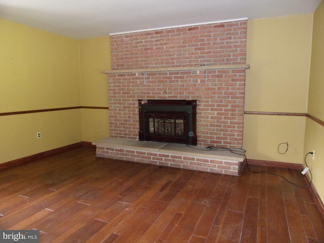 142 Fawn Rd, Reedsville, PA 17084 - unfurnished living room with wood-type flooring, a brick fireplace, and baseboards