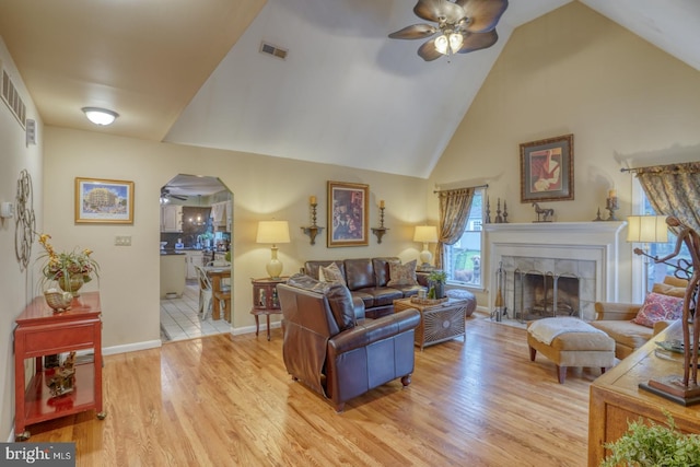 7857 Holly Branch Dr, Laurel, DE 19956 - living room featuring a ceiling fan, high vaulted ceiling, arched walkways, light wood finished floors, and a fireplace