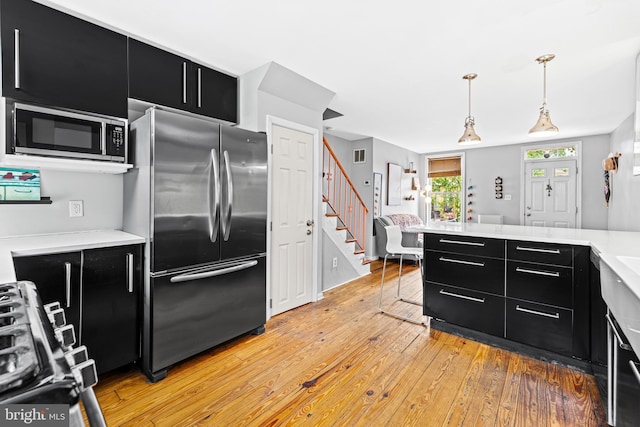 907 Mchenry St, Baltimore, MD 21223 - kitchen with dark cabinetry, appliances with stainless steel finishes, light wood-style flooring, and light countertops